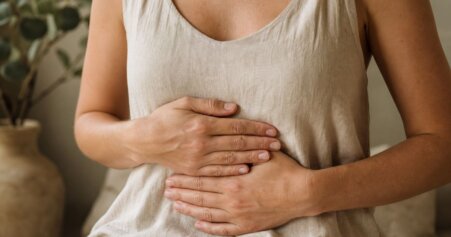 Hände liegen sanft auf dem Bauch – Symbol für Vagusnerv-Aktivierung, Körperbewusstsein und die Darm-Hirn-Achse.