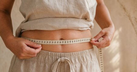 Eine ruhige Nahaufnahme der weiblichen Körpermitte in warmem, natürlichem Licht – symbolisch für Taillenumfang als Gesundheitsmarker.