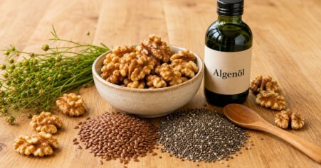 Stillleben mit Walnüssen, Leinsamen, Chiasamen und einem Fläschchen Algenöl als pflanzliche Omega-3-Quellen auf Holzuntergrund.