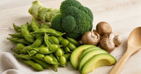 Stillleben mit Edamame, Brokkoli und Avocado als natürliche NMN-Quellen. Frische Lebensmittel auf Holzuntergrund mit warmem natürlichen Licht.