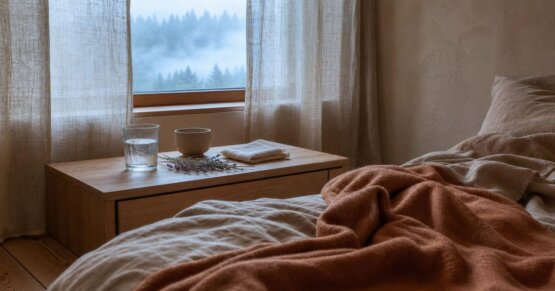 Stilles Morgenlicht durch Fenster auf einem ungemachten Bett – Stimmungsbild für Müdigkeit vor der Periode.