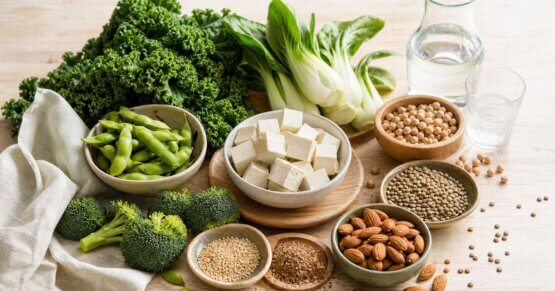 Stillleben mit Mandeln, Grünkohl, Tofu, Edamame und Leinsamen auf Holzbrett – pflanzliche Lebensmittel für die Postmenopause.