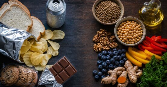 Stillleben mit ultra-verarbeiteten Lebensmitteln links und entzündungshemmender Vollwertkost rechts – westliche Ernährung und Entzündung im direkten Vergleich.